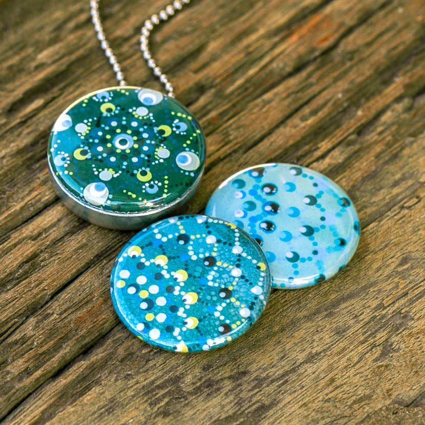 Fotomedaillon ketting met 3 verschillende verwisselbare voorkanten met foto`s van 3 verschillende dotting art kunstwerken.Blauw tinten dotting art.