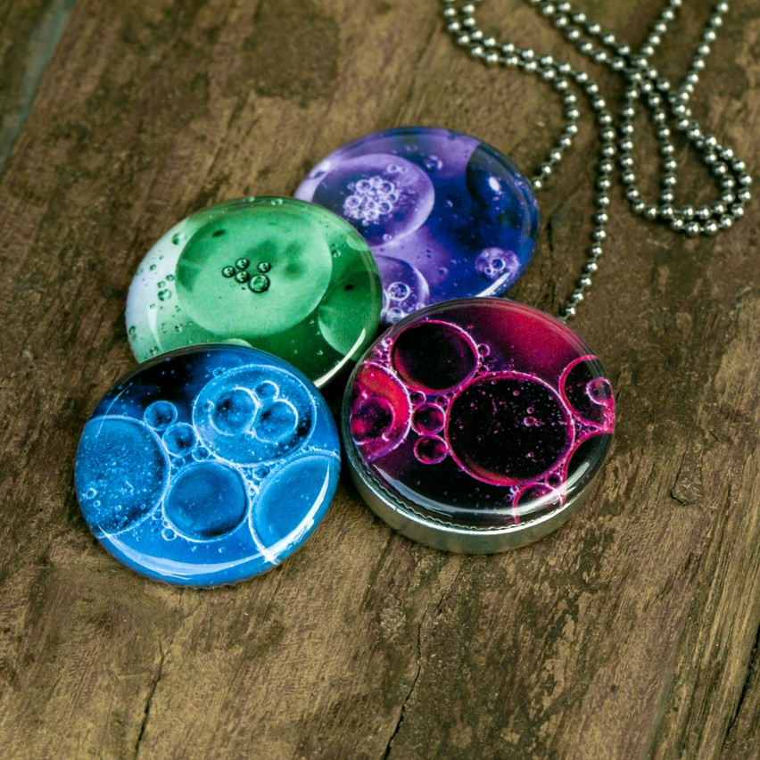 Foto medaillon ketting met 4 verschillende verwisselbare voorkanten met close up foto`s van olie bellen in verschillende kleuren.