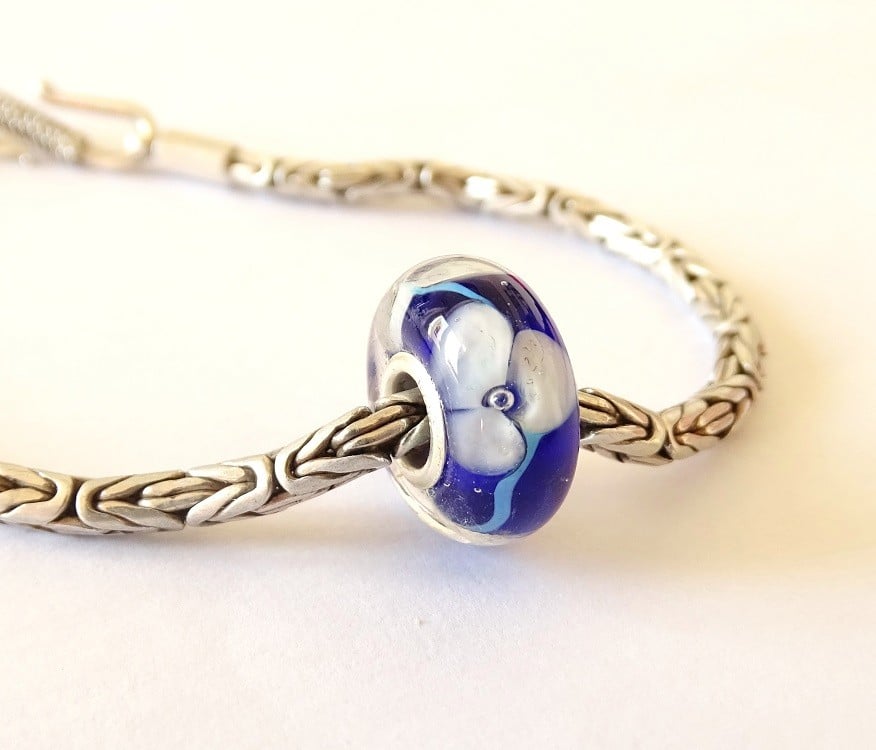 Handgemaakte donkerblauwe lampwork glasbedel met parelmoeren bloemen