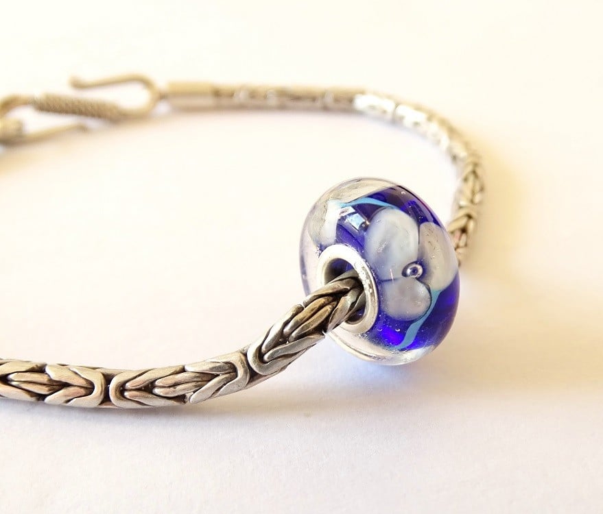 Handgemaakte donkerblauwe lampwork glasbedel met parelmoeren bloemen