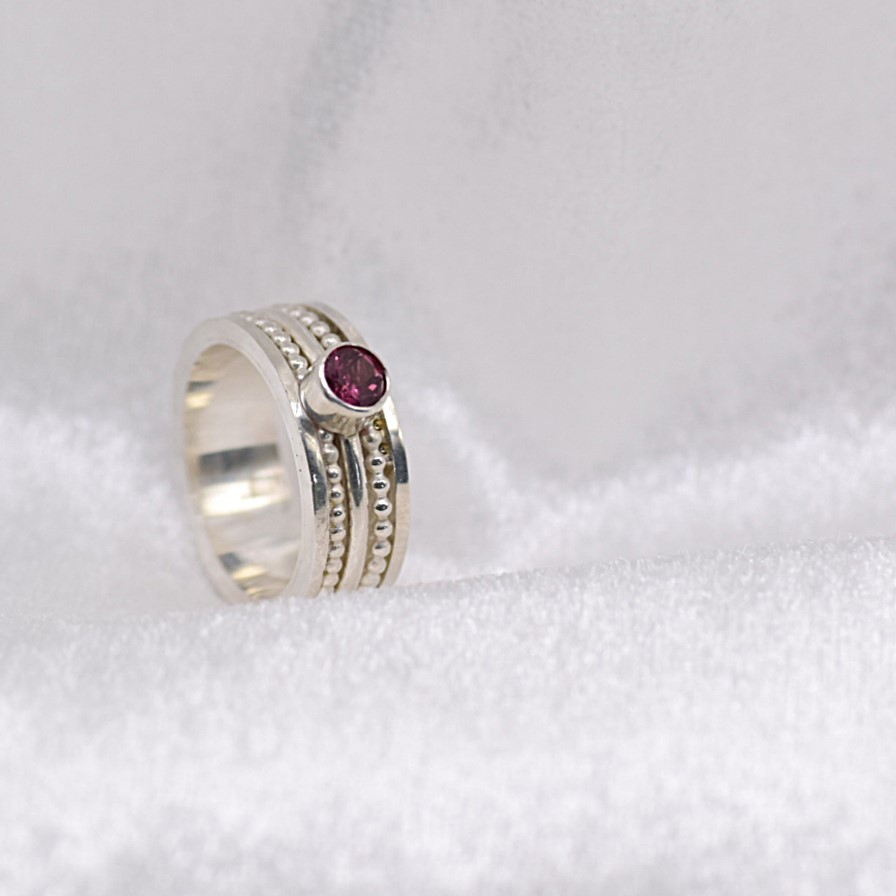 Vier zilveren ringen samengevoegd tot één – met roze toermalijn