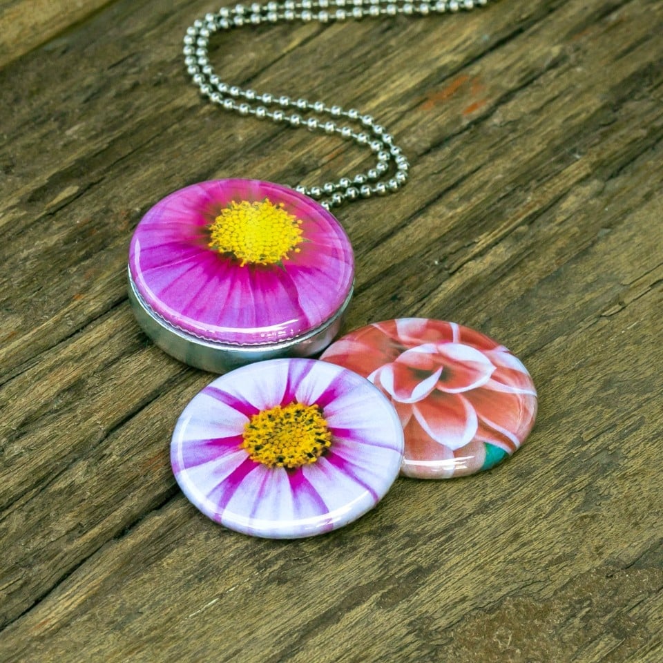 Roestvrij stalen fotomedaillon ketting met drie verschillende verwisselbare voorkanten met close up foto`s van roze,witte en zalm kleurige bloemen. Rvs/roestvrij stalen fotomedaillon. Voor het dicht bij je dragen van je favoriete foto.